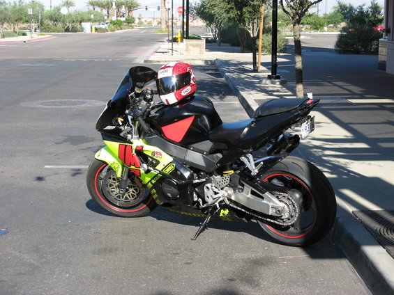 Black and yellow sport motorcycle with red accents and a red helmet on the seat