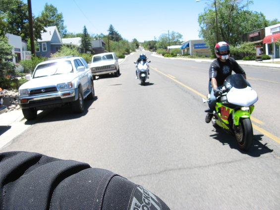 Green motorcycle with white fairing and rider in helmet