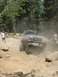 1995 Ford Bronco - A 1995 Ford Bronco tackles a challenging off-road course, kicking up dust as it maneuvers over rocks.