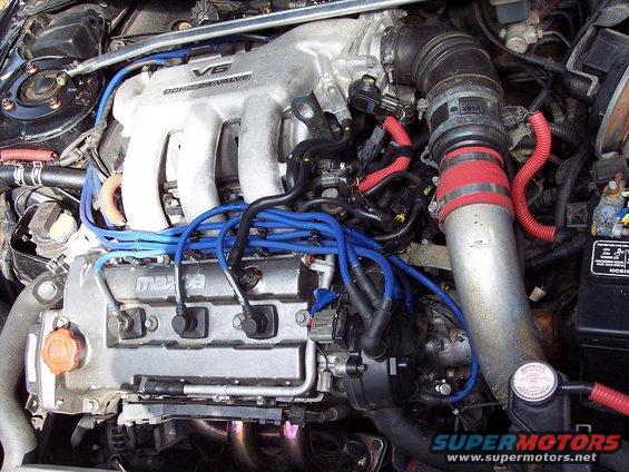 Mazda V6 engine with blue spark plug wires and red hose accents