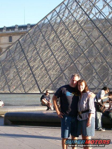 Couple posing in front of the Louvre Pyramid in Paris