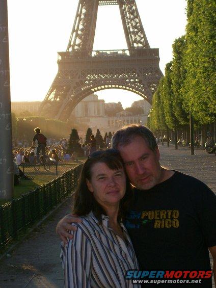 Couple posing for a photo with the Eiffel Tower in the background