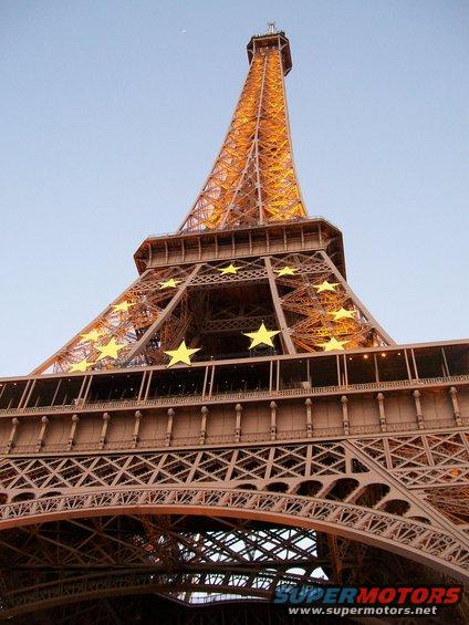 Eiffel Tower with yellow stars against a clear blue sky