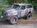 1979 Ford Bronco - This lifted 1978 Ford Bronco is painted in a camouflage pattern and sits on a dirt road surrounded by trees.