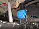 1979 Ford Bronco - Undercarriage view of a vehicle's suspension system, focusing on a blue block and shock absorber.