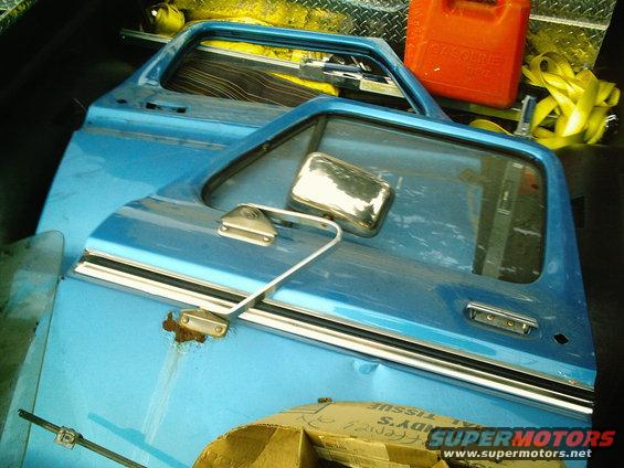 Two blue truck doors with chrome mirrors and trim, one door is slightly ajar