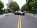 2000 Ford Crown Victoria - A dark gray 2000 Ford Crown Victoria drives down a tree-lined street during a parade.