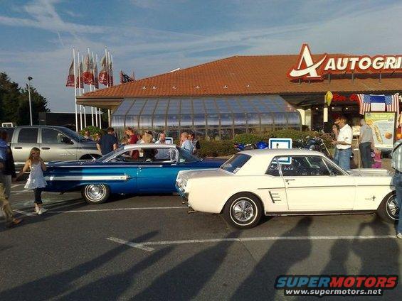 White 1965 Ford Mustang coupe parked next to a blue car