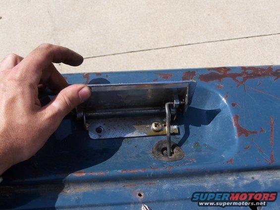 Blue tailgate handle with chrome trim and a keyhole