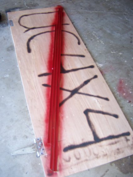 Wooden door with red trim and black spray paint