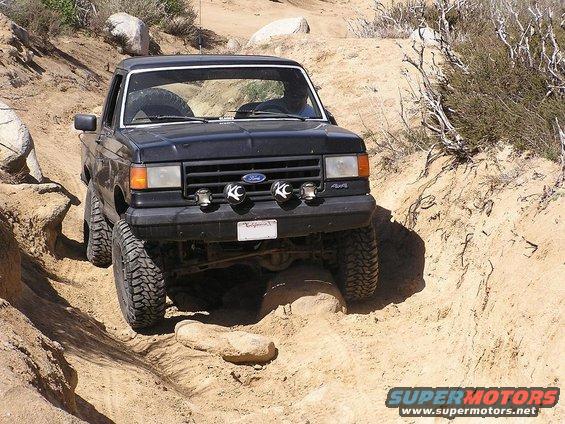 Black Ford Bronco navigating a rocky, sandy trail
