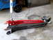 1996 Ford Bronco - Aftermarket suspension control arms and a shock absorber are laid out on a concrete floor.