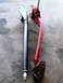 1996 Ford Bronco - Two automotive suspension control arms, one silver and one red, are displayed on a concrete surface.
