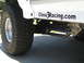 1996 Ford Bronco - Close-up of a white SUV's side, large off-road tires and the text "Class3Racing.com" alongside visible suspension components.