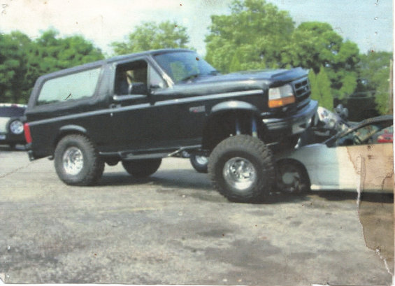 Black Ford Bronco with lifted suspension crushing a white car