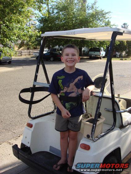 golf-cart-christian.jpg here is the new golf cart with Christian on the back. we used the golf bag tie down to belt him in. he loved this.