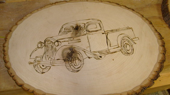 wood burning of a classic pickup truck on a slice of wood