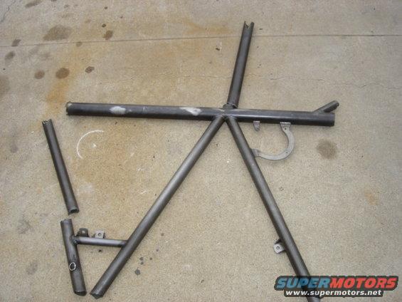 Metal roll cage section with several tubes welded together, lying on concrete