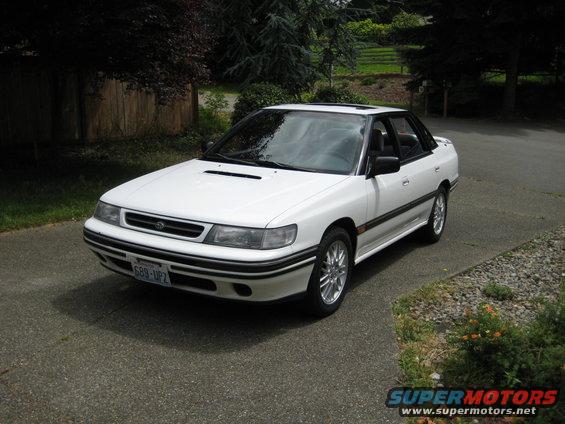 White Subaru Legacy sedan parked on asphalt driveway