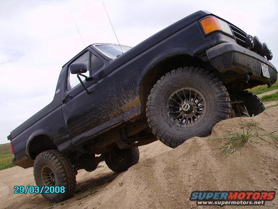 Dark blue SUV climbing a dirt hill at an angle