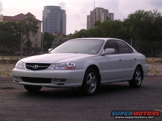 White 2003 Acura TL parked on asphalt with buildings in background