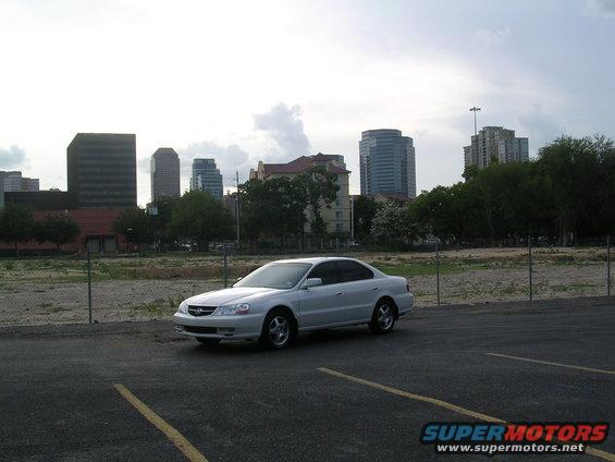 White 2003 Acura TL parked with city skyline behind it