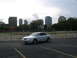 2003 Acura TL - A white 2003 Acura TL is parked in a lot, with a city skyline visible in the distance.