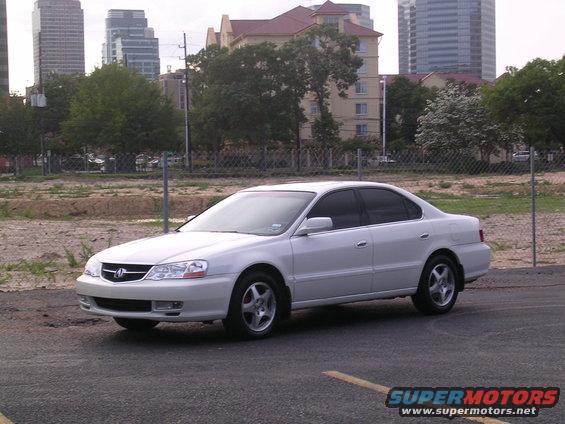 White 2003 Acura TL parked on asphalt with buildings in the background