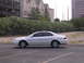 2003 Acura TL - A white sedan is parked in an asphalt lot with buildings and trees visible behind a fence.