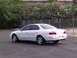 2003 Acura TL - The rear-right view of a white 2003 Acura TL sedan shows its taillights and dual exhaust pipes.