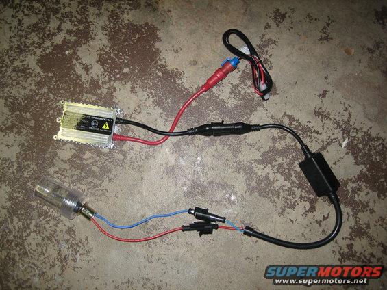 HID ballast and bulb assembly with wiring laid out on concrete floor