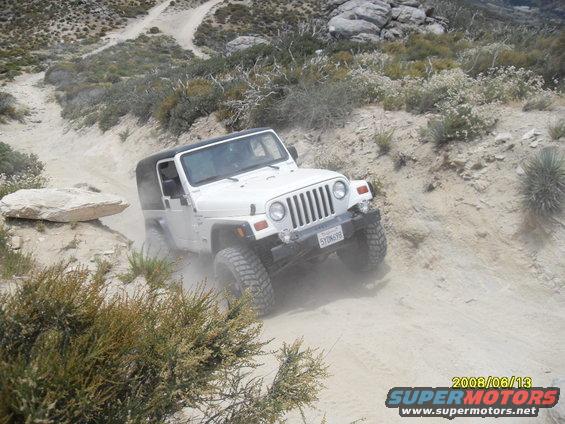 White Jeep Wrangler on a dusty trail