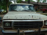 Front view of a 1978 Ford Bronco with a dented hood and grille