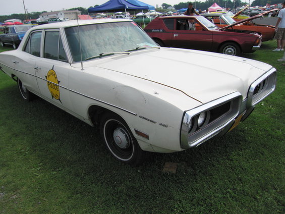 White 1970 Dodge Coronet 440 police car with yellow and black seal on door
