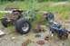 1989 Ford Bronco II - Disassembled vehicle frame and engine components lie in a grassy, overgrown area.