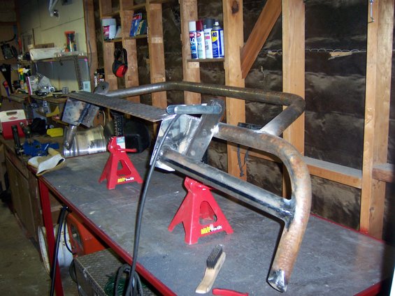 Custom fabricated metal bumper assembly on red jack stands in a workshop