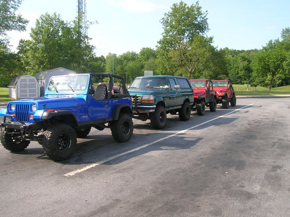 Green Ford Bronco SUV parked in a line with other vehicles