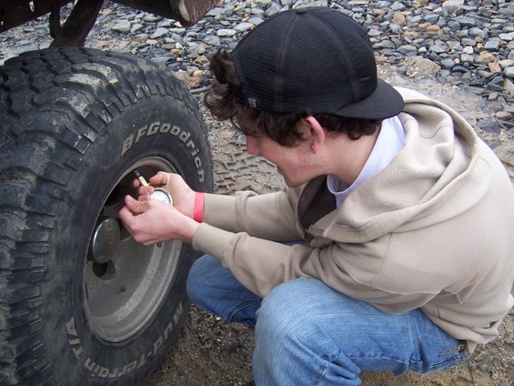 Man checking tire pressure on a BFGoodrich Mud-Terrain tire