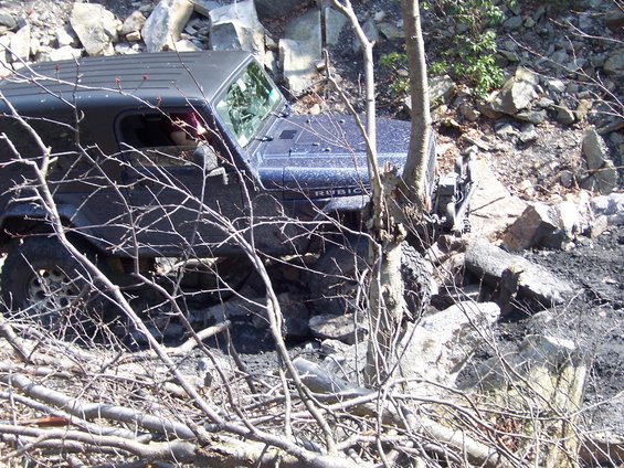 Dark Jeep Wrangler Rubicon navigating a rocky off-road trail
