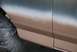 1996 Ford Bronco - The side panel of a vehicle is shown during a two-tone paint application, with a gradient from blue to brown.