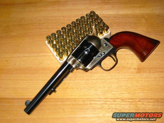 Revolver with wooden grip and a box of cartridges on a wooden surface