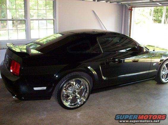 Black 2007 Ford Mustang GT coupe with chrome wheels parked in a garage