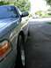 1998 Ford Crown Victoria - A silver 1998 Ford Crown Victoria is seen from the front quarter angle, with a timestamp visible on the headlight.