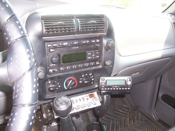 Interior shot of a 2003 Ford Ranger showing the dashboard, steering wheel, gear shift, and aftermarket CB radio