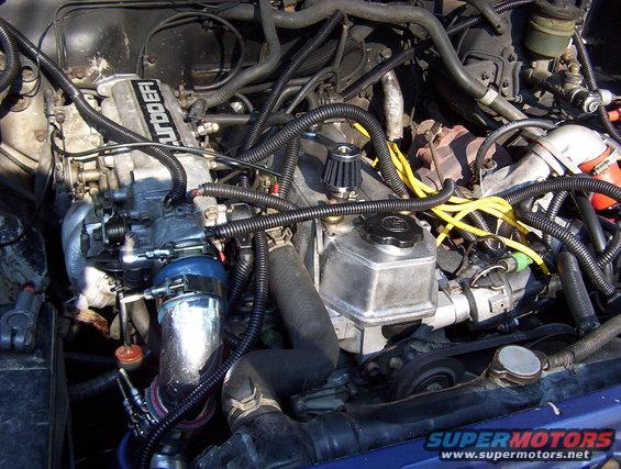 Engine bay showing turbocharger, intake piping, and engine components. Text on intake manifold reads 'TURBO EFI'