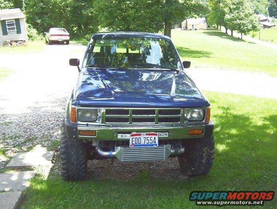 1986 Toyota Hilux pickup truck front view, blue, with aftermarket intercooler visible below grille