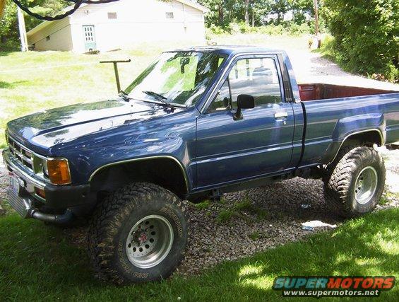 Blue pickup truck with lifted suspension and large tires