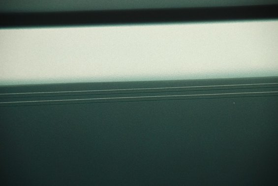 Dark green textured surface with horizontal lines and bright upper section