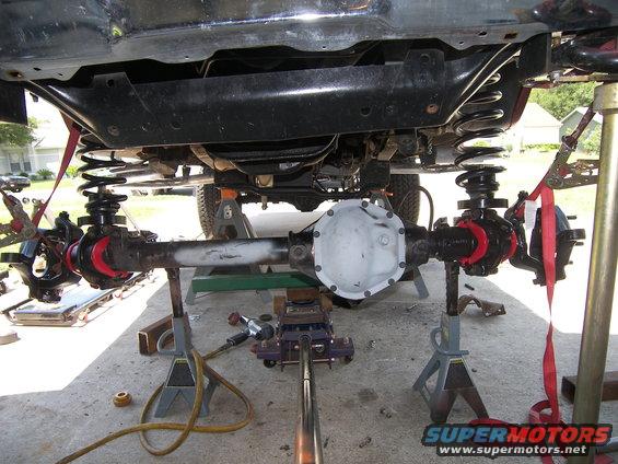 Undercarriage view of a vehicle's suspension and differential on jack stands