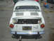 1985 Ford Mustang - Rear view of a white Fiat 850, trunk open, revealing the engine compartment.